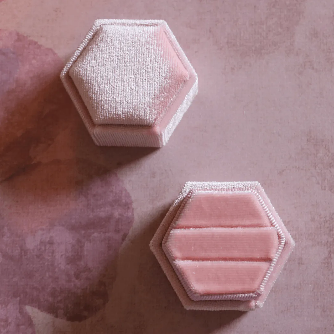 Twee roze velvet ringdoosjes in hexagonvorm, een ervan open met twee inkepingen